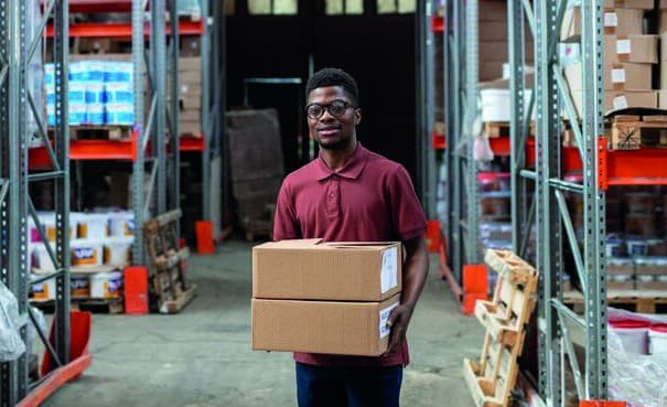 A Gravan team member moving packaged stock through a supply warehouse.