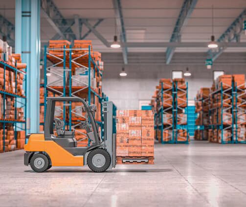 A forklift moving palletised stock through a warehouse aisle.
